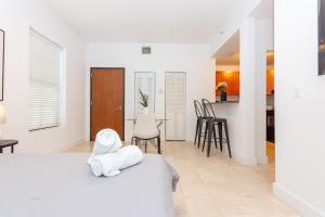 um quarto branco com uma cama e uma cozinha em 1 BDRM Apartment - heart of Downtown - 5 min to Wynwood em Miami