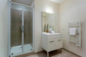 La salle de bains est pourvue d'une douche et d'un lavabo. dans l'établissement Villa Marcelline - Lyon, à Sainte-Foy-lès-Lyon