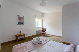 - une chambre avec un lit et des serviettes dans l'établissement Villa Marcelline - Lyon, à Sainte-Foy-lès-Lyon