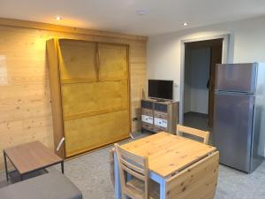 a kitchen with a table and a refrigerator at Résidence Croix Margot in Villard-de-Lans