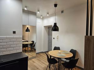 - une cuisine et une salle à manger avec deux tables et des chaises dans l'établissement Apartamenty Skawińska 10, à Cracovie