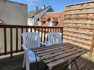 Bischheim的住宿－Joli appart Bischheim +terrasse，阳台上配有两把白色椅子和一张木桌