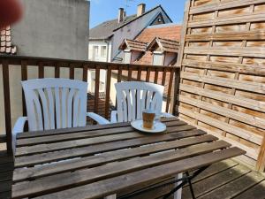 Bischheim的住宿－Joli appart Bischheim +terrasse，一张带两把椅子的木桌和一杯咖啡