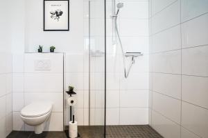a white bathroom with a shower and a toilet at O24 Neu I Zentral I Parkplatz I Fahrstuhl I Design I King I Küche in Ibbenbüren