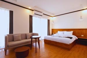 een hotelkamer met een bed en een bank bij Oudomsin VangVieng Hotel in Vang Vieng