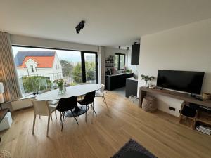 东代恩凯尔克Kenydou 0101G的客厅配有白色桌子和大窗户