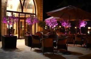 un restaurante con mesas, sillas y árboles púrpuras en L'auberge des Emirs, en Dayr al Qamar