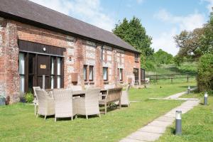 Newfield Farm Cottages في بلاندفورد فوروم: طاولة وكراسي أمام مبنى من الطوب