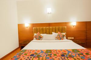 een slaapkamer met een groot bed met houten lambrisering bij FabHotel Royale Basant Residency - Gandhinagar in Bangalore