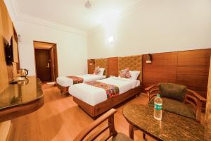 a hotel room with a bed and a couch at FabHotel Royale Basant Residency in Bangalore