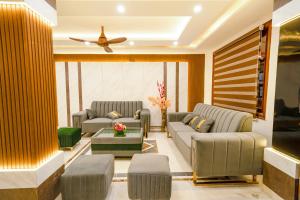 a living room with couches and a ceiling fan at FabHotel Royale Basant Residency in Bangalore