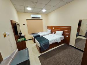 a hospital room with two beds and a tv at Villa Hotel Basra in Al Başrah