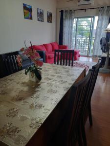 uma sala de estar com uma mesa com um vaso de flores em Ratu Homestay em Kuala Selangor