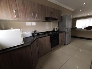 a kitchen with wooden cabinets and a refrigerator at Arabella in Durban