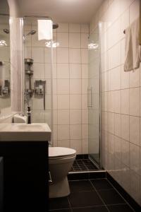 uma casa de banho com um WC, um chuveiro e um lavatório. em Eksjö Stadshotell em Eksjö