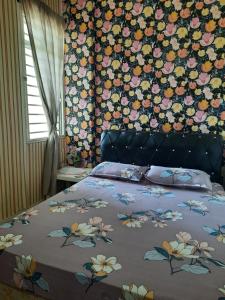 um quarto com uma cama com uma parede floral em Ratu Homestay em Kuala Selangor