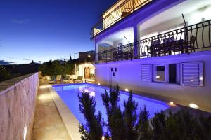 a villa with a swimming pool at night at Villa Maestral with pool Ciovo in Trogir