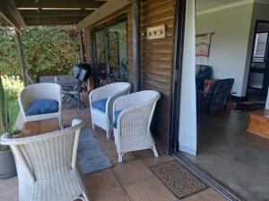 eine Gruppe Stühle und ein Tisch auf einer Veranda in der Unterkunft 9 Stoney Way Cottage in Underberg