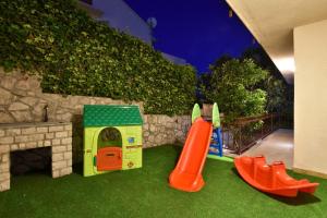 a play area with a toy house and a playground at Villa Maestral with pool Ciovo in Trogir