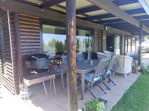 eine Terrasse mit einem Tisch, Stühlen und einem Grill in der Unterkunft 9 Stoney Way Cottage in Underberg