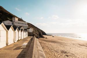 een rij strandhutten op een zandstrand bij Les Dunes - Duplex - 6 personnes in Jullouville-les-Pins