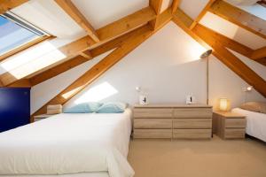 een slaapkamer op zolder met 2 bedden en een raam bij Les Dunes - Duplex - 6 personnes in Jullouville-les-Pins