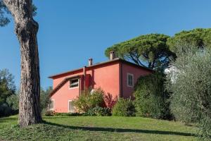 una casa roja con un árbol delante en Villa Flavia, en Manziana