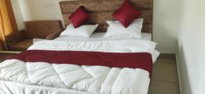 a bedroom with two beds with white and red pillows at Hotel Lake View Paradise in Uttarkāshi