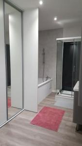 a bathroom with sliding glass doors and a red rug at Aux Docks Rémois in Bétheny