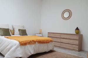 ein Schlafzimmer mit einem Bett mit einer Kommode und einem Spiegel in der Unterkunft Aux Docks Rémois in Bétheny