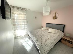 una camera bianca con un letto e una finestra di Appartement avec piscine proche de la mer a La Londe-les-Maures