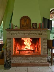 a fireplace in a living room with a fire in it at Lovćen Escape, Rustric House in Cetinje +14 photos