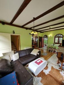 a living room with a leather couch and a table at Lovćen Escape, Rustric House in Cetinje