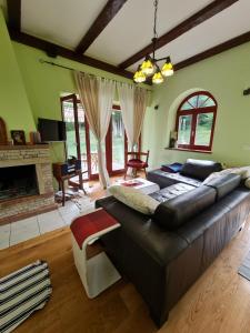 a living room with a large couch and a fireplace at Lovćen Escape, Rustric House in Cetinje