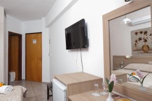 uma sala de estar com televisão na parede em Akti Corali Hotel em Amoudara Herakliou