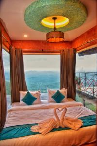 a bedroom with a bed with a large window at Vayalada View Point Resort in Kozhikode