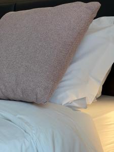 ein Kissen auf einem weißen Bett in der Unterkunft Green House in Bassano del Grappa