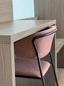einen Schreibtisch mit einem rosa Stuhl unter einem Schreibtisch in der Unterkunft Green House in Bassano del Grappa