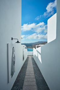 a hallway of white walls with a view of the water at Myconian Avaton, a Member of Design Hotels in Elia Beach