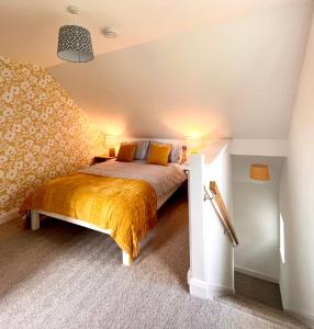 a bedroom with a bed with a yellow blanket at The Annex, Escape to the Country in Salcombe