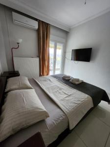 a bedroom with a large bed with a television on the wall at 4ALL Airport 10min,Sea100m,Free parking in Thessaloniki