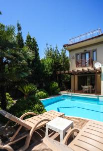 una piscina con due sedie e una casa di Villa Özgür a Ortaca