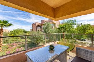 un patio con tavolo e sedie sul balcone. di Golf Prestigia, grande piscine, jardins a Marrakech