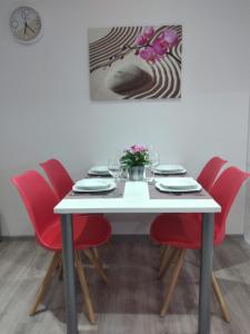 uma mesa de jantar com cadeiras vermelhas e uma mesa branca em Apartman NIKA em Daruvar