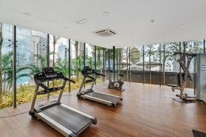 un gimnasio con equipo cardiovascular en un edificio con ventanas en Dorsett Residences Kuala Lumpur 3mins to Pavilion Shopping Mall, en Kuala Lumpur
