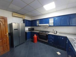 a kitchen with blue cabinets and a stainless steel refrigerator at Beautiful Luxury Villa in Dubai near Airport in Dubai