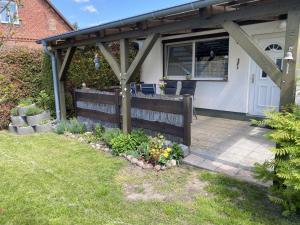 a wooden pergola on a house with a patio at NEU! Bungalow am Kummerower See TOP in Verchen