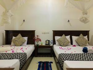 a bedroom with two beds with flowers on them at Lucky Villa Sigiriya in Sigiriya