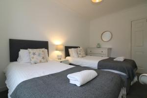 2 camas en una habitación con 2 camas blancas en Signature - Bruce Terrace Upper - Blantyre, en High Blantyre
