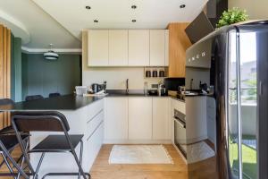 a kitchen with white cabinets and a black counter top at Appartement spacieux avec balcon 6pers in Lyon